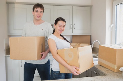Removal workers carrying furniture through a narrow Notting Hill staircase
